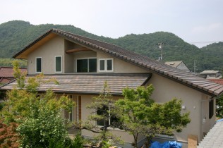 大きな屋根に守られる2世帯住宅の写真