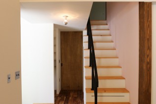 グレーピンクの壁とスチール手すりの階段の写真